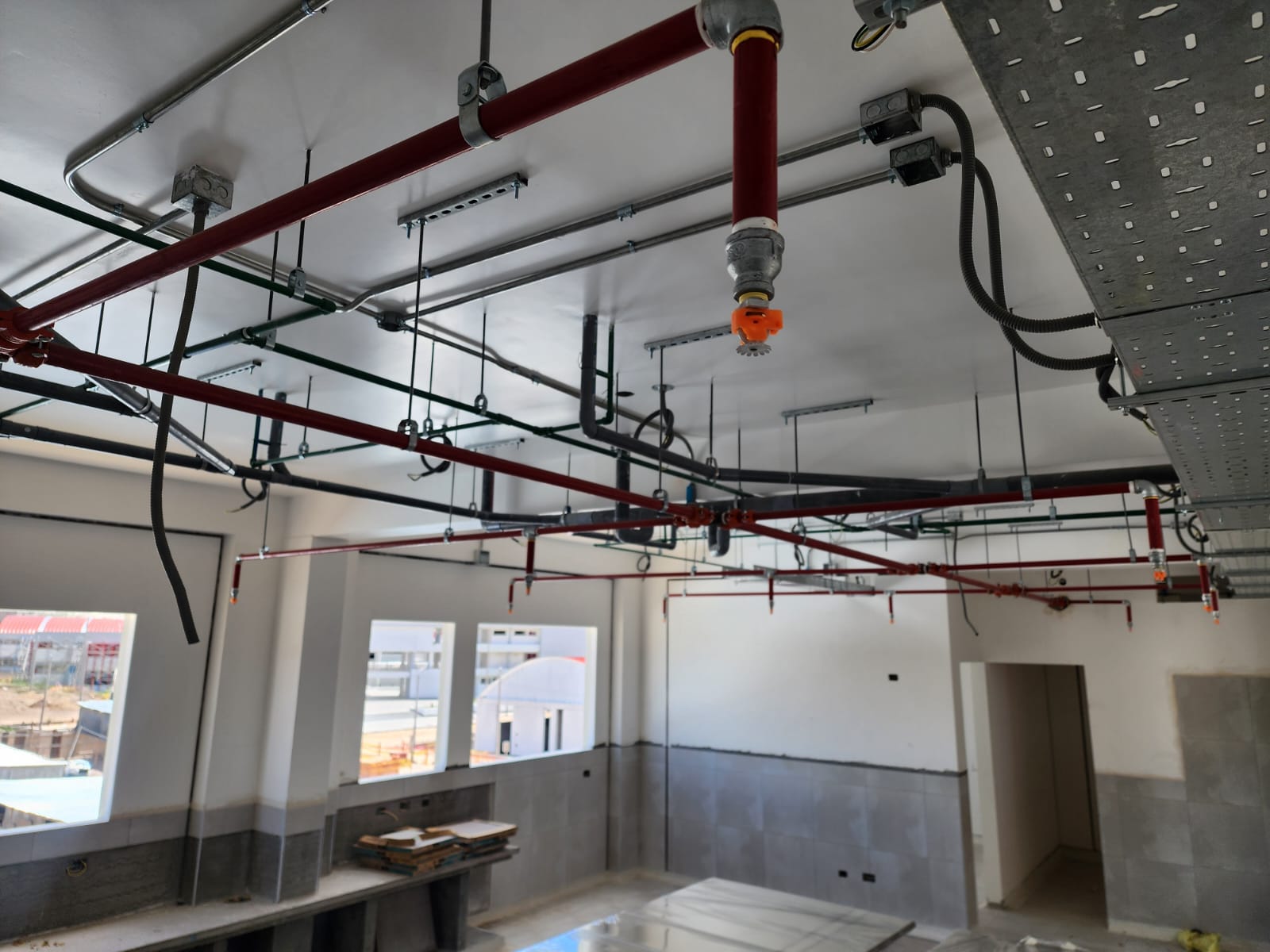 Técnico trasladando tubería en corredor de obra